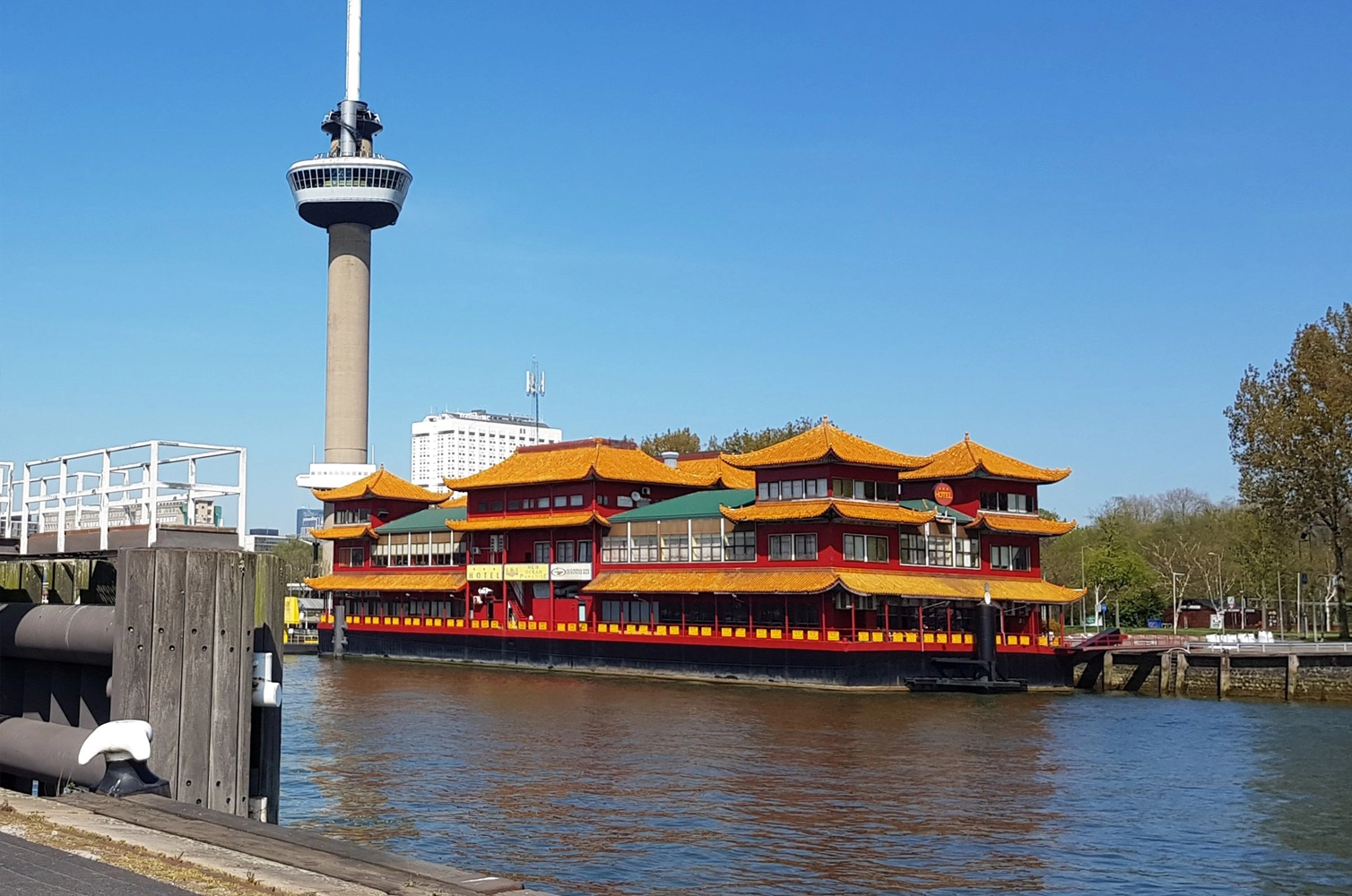 De Chinese Boot, a floating Chinese restaurant and market on the Maas River in Rotterdam, docked near the Euromast